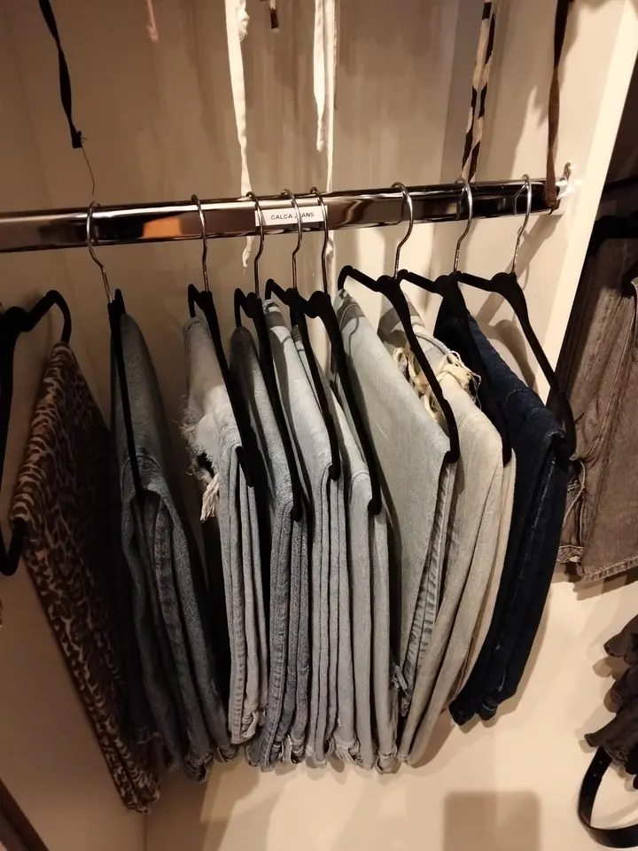 Calças jeans penduradas em cabides de veludo