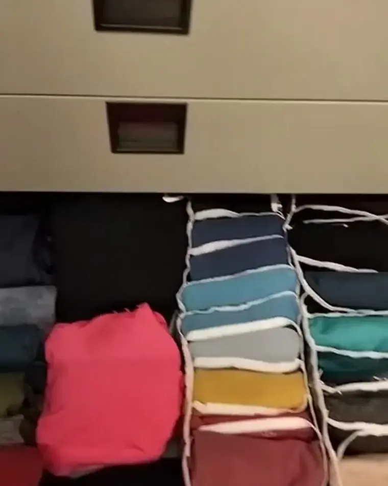 Gaveta com roupas dobradas em divisórias
